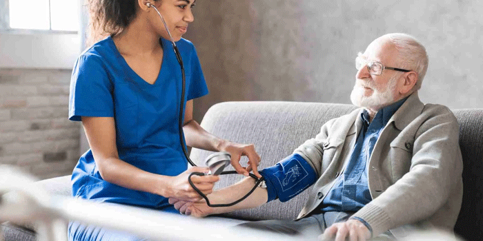 A nurse checking a participant's blood pressure at home