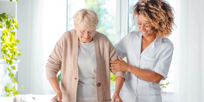 A participant with a walking frame building confidence with their support worker