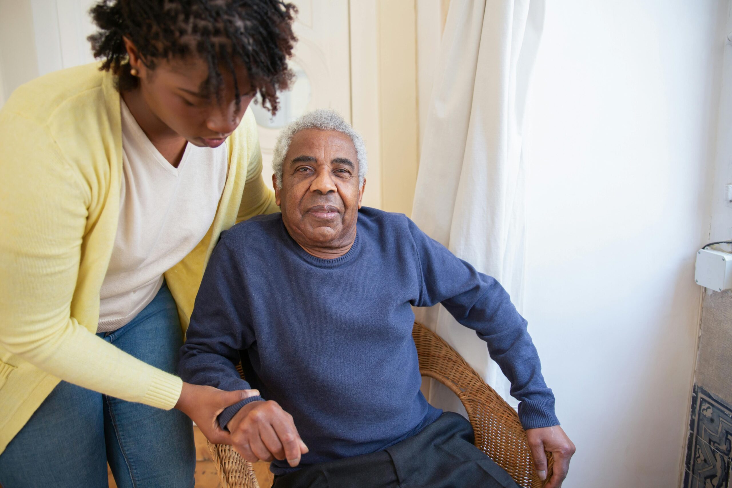 A support worker helping a participant move safely at home