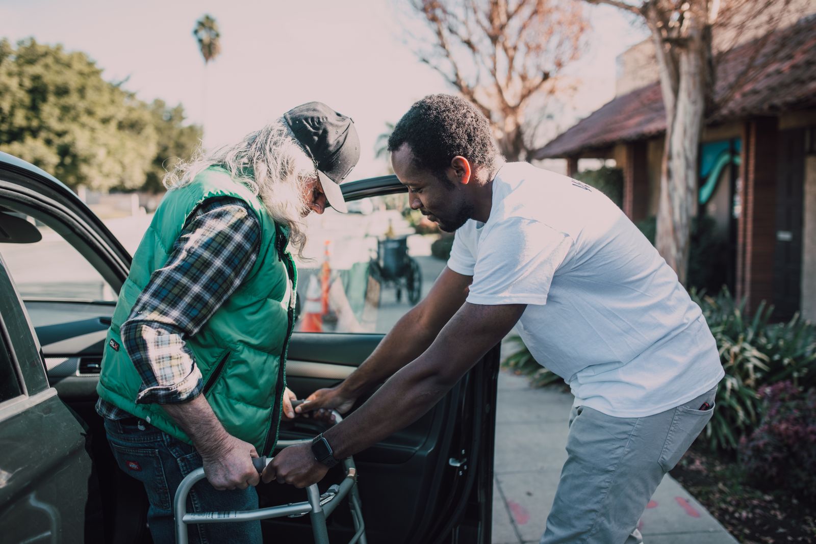 A support worker helping a participant into a vehicle